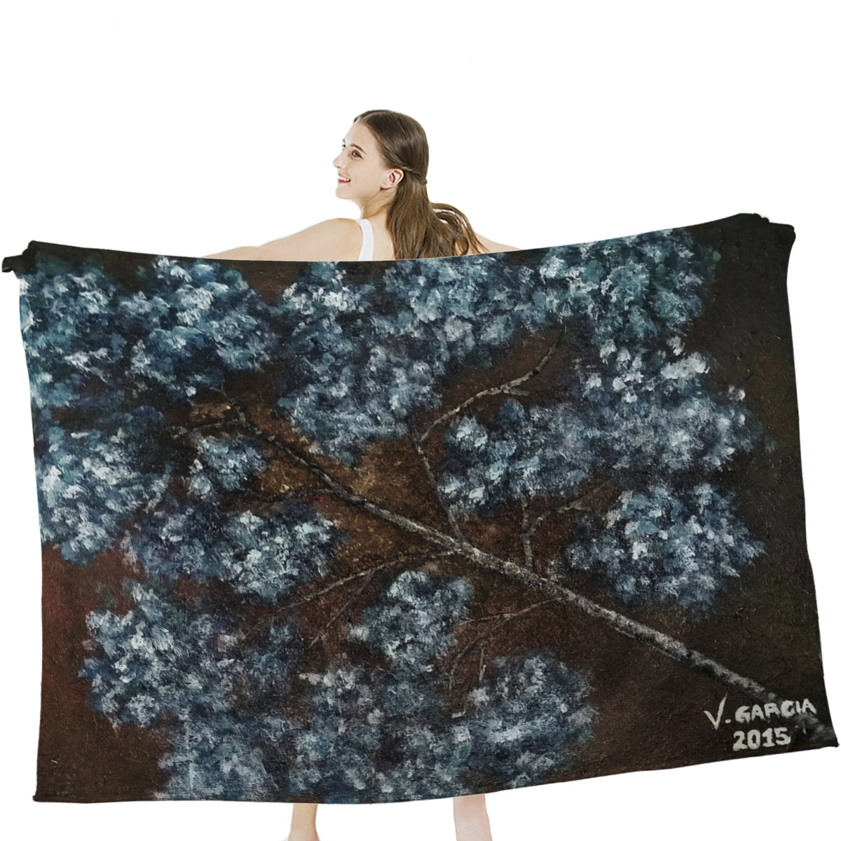 Woman holding soft, anti-pilling Bangs Garci blanket with tree design, made from hypoallergenic microfiber.